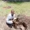 An image of Bikoro with a loquat tree seedling in hand ready for planting
